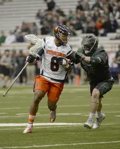 Syracuse midfielder Hakeem Lecky scans the field as a defender provides pressure. 