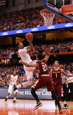 Michael Gbinije elevates for a layup over Boston College's Olivier Hanlan. SU's junior forward led the team with 11 first-half points.