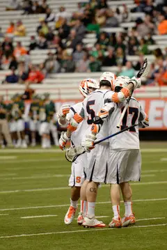 Galasso embraces Dylan Donahue and another teammate after an SU goal.