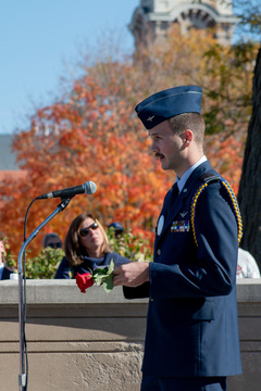 Adam Landry, one of the 2022 Remembrance Scholars, takes his turn at the microphone to say a statement about the individual he represents. Suited in his dress blues, Landry laid his rose for Stephen Boland. 