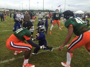 A kid runs right into Syracuse freshman Jamal Custis during a drill with the tight ends at the youth clinic at Fort Drum on Thursday. 