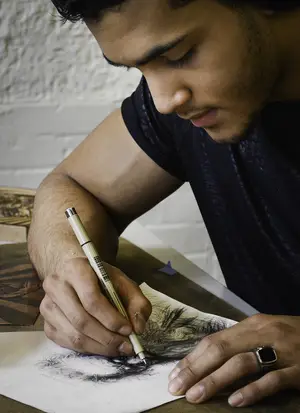 Bernardo Rodriguez sketches a drawing. He began exploring art after moving to America from the Dominican Republic. He had his first art show last summer.