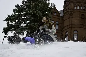 Jessica Crawford, a sophomore costume design major from New York City, sleds down the hill on Crouse College, a favorite sledding spot among Syracuse University students. Crawford, who had never gone sledding in her life, went for the first time this weekend.  