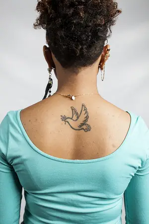 Daisia Glover has a tattoo of a dove holding an olive branch from the biblical story of Noah's Ark. The tattoo is a daily reminder of faith and optimism. 
