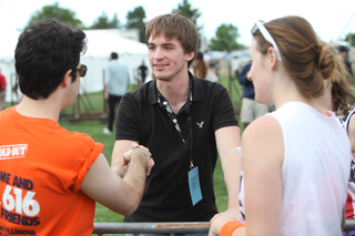 Stephen Barton, an SU graduate shot in the Aurora, Colo., theater shooting, shakes hands with a student .