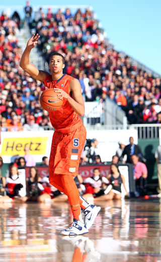 Michael Carter-Williams of the Syracuse Orange signals to teammates as he takes the ball down the court against the San Diego State Aztecs during the Battle on the Midway game on Sunday.