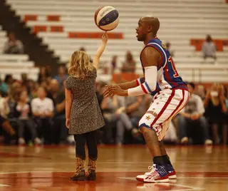 Scooter holds the Guinness World Record for the longest time spinning a basketball on one's head and one's nose. Friday, as part of one of the Globetrotters' classic tricks, he passed on his skills to a lucky fan, helping to spin the ball on her finger for a few seconds. 