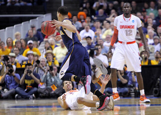 Michael Carter-Williams falls as a charging foul is called on California's Justin Cobbs late in Syracuse's win over the Golden Bears.