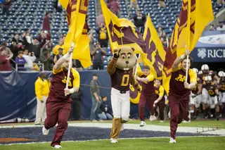 Goldy Gopher leads the Gophers out of the tunnel.