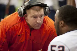 Syracuse defensive line coach Tim Daoust talks with nose tackle Eric Crume. 
