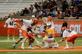 Three Syracuse players fight an Albany player in the fight for ball possession.