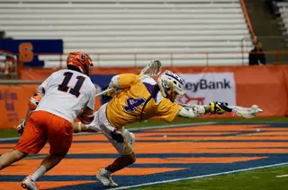 Lyle Thompson extends his arms for a ball behind the net. 