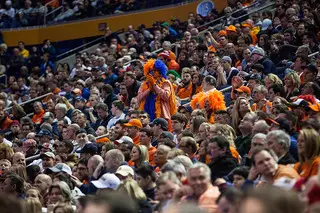 A die-hard Syracuse fan stands in the middle of the fan section. 