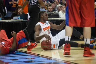 Grant sits on the ground after battling for a loose ball with a Dayton player.