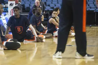 The Syracuse players stretch out as trainer Brad Pike looks on in the background.