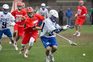 A Duke and Syracuse player jostle for a groundball. On the day, the Blue Devils picked up 38 groundballs to SU's 17. 