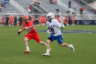 Blue Devils midfielder Tanner Scott is shadowed by a Syracuse defender as he carries the ball upfield. 