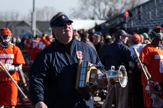 Director of Operations Roy Simmons III carries the Kraus-Simmons Trophy after Syracuse's victory.