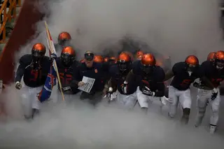 Head coach Scott Shafer and his team charge out of the tunnel and onto the field.