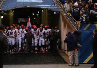 SU head coach Scott Shafer leads his team out of the tunnel and onto the field.