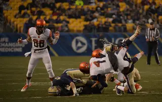 SU quarterback AJ Long is taken down by a Panthers defender as wide receiver Jarrod West looks on.
