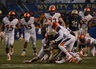 A pair of Syracuse defenders converge to bring down a Pittsburgh ball-carrier.
