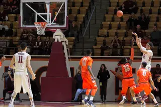 VT's Satchel Pierce releases a midrange jumper over the outstretched right arm of Christmas.