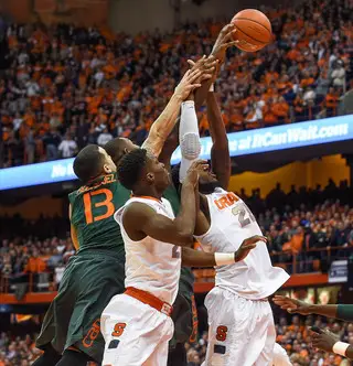 Roberson looks to pull down a rebound from Miami guard Angel Rodriguez.