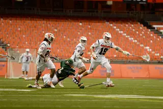 Jeff Desko holds onto his stick with one hand to avoid a Siena defender. 