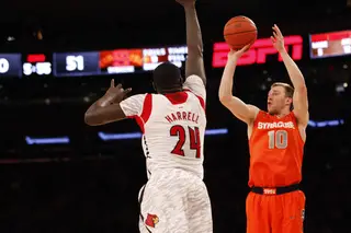 Trevor Cooney attempts to shoot a three point shot while Louisville's Montrezl Harrell (#24) defends.